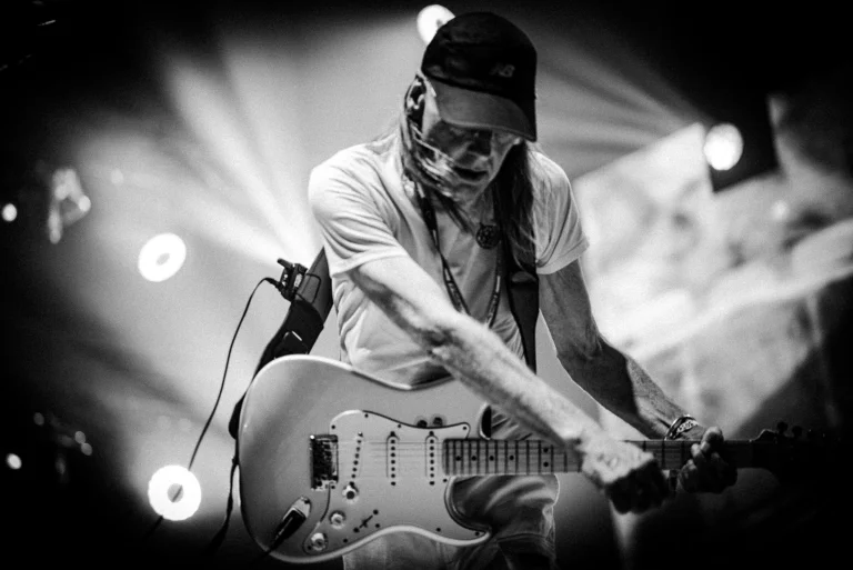 Artysta Tomek Lipiński z gitarą w trakcie koncertu